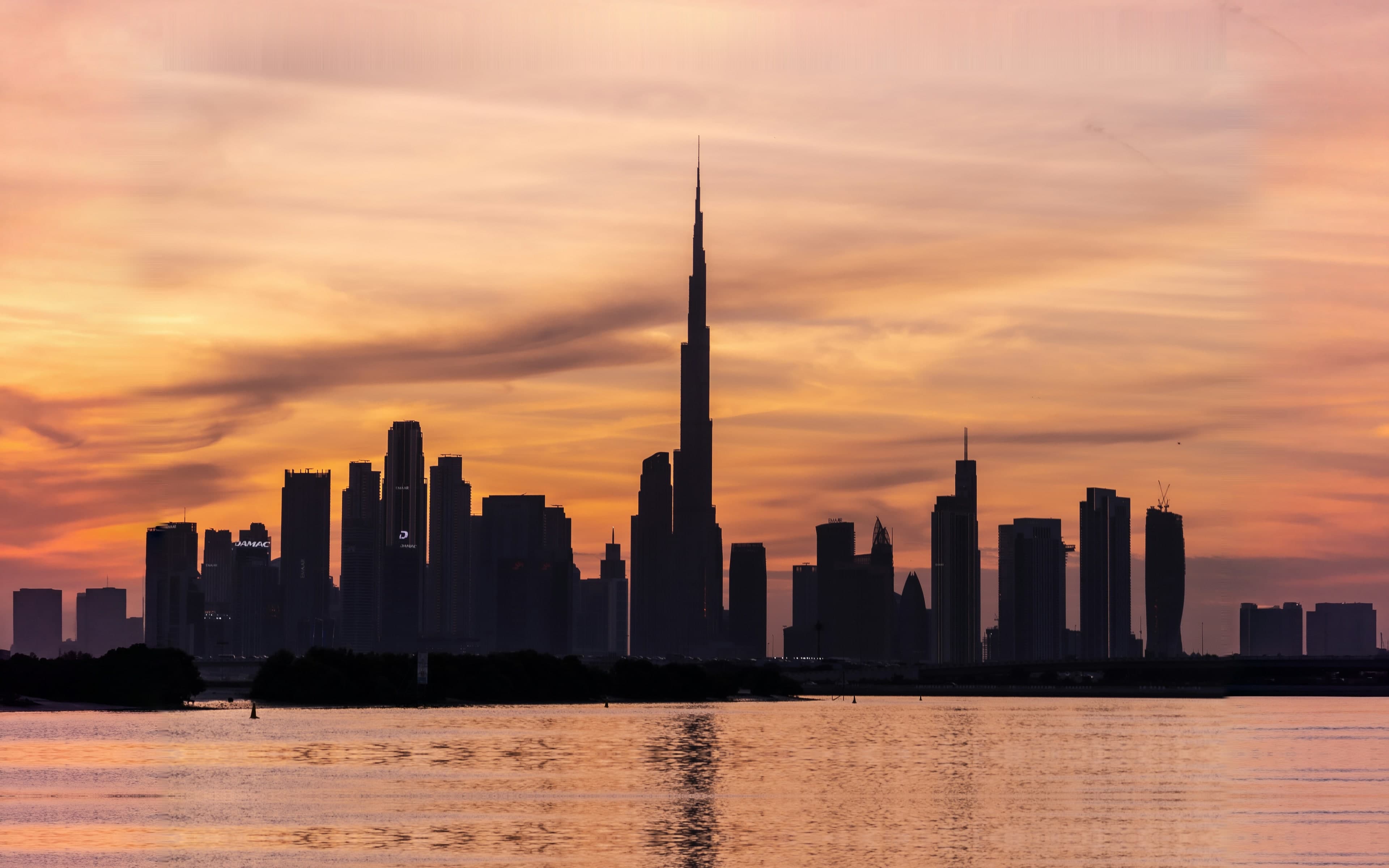 Burj Khalifa and the Downtown Dubai skyline in silhouette at sunset